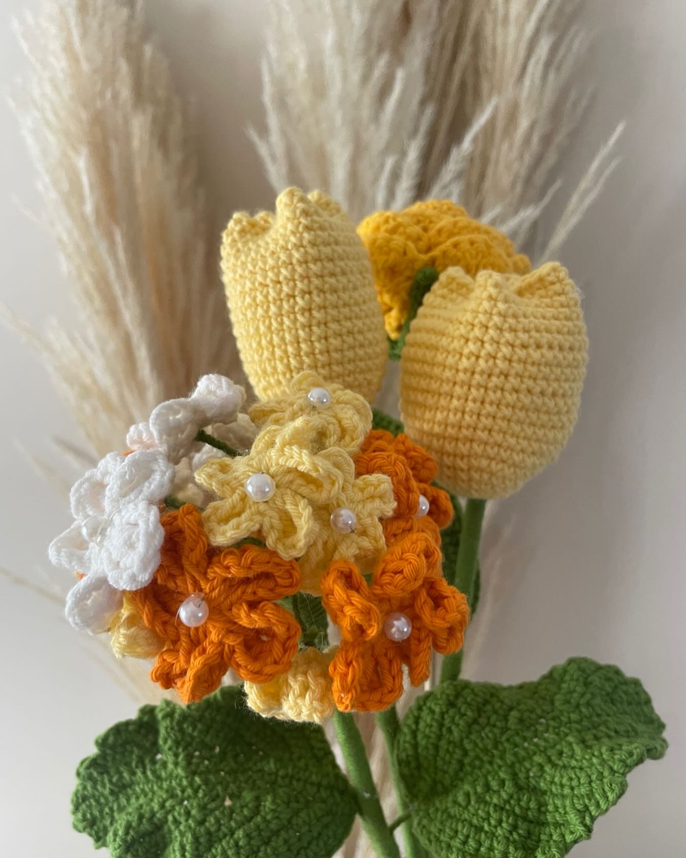 Rosa tejida a crochet en tonos durazno sobre fondo crema